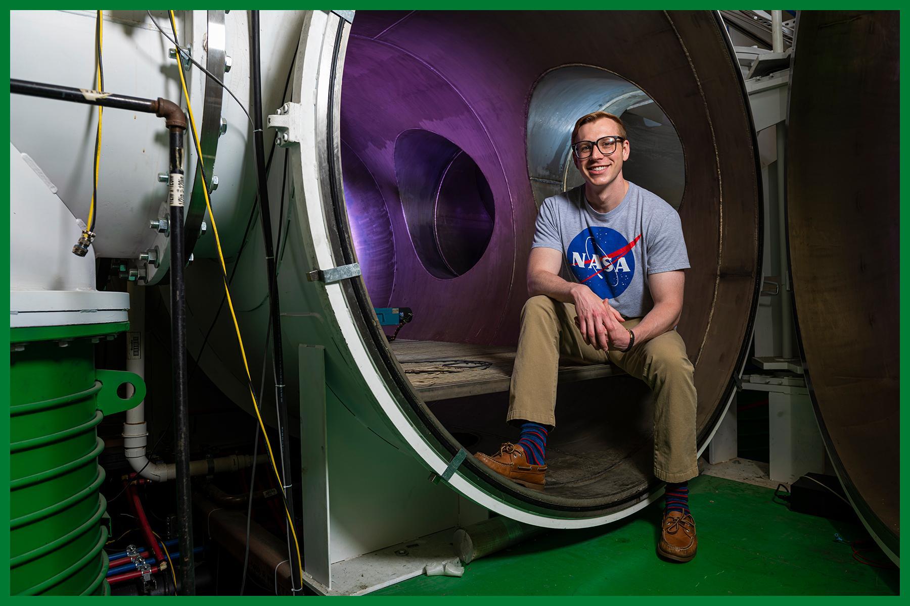 Color phtos of a student sitting at edge of vacuum chamber