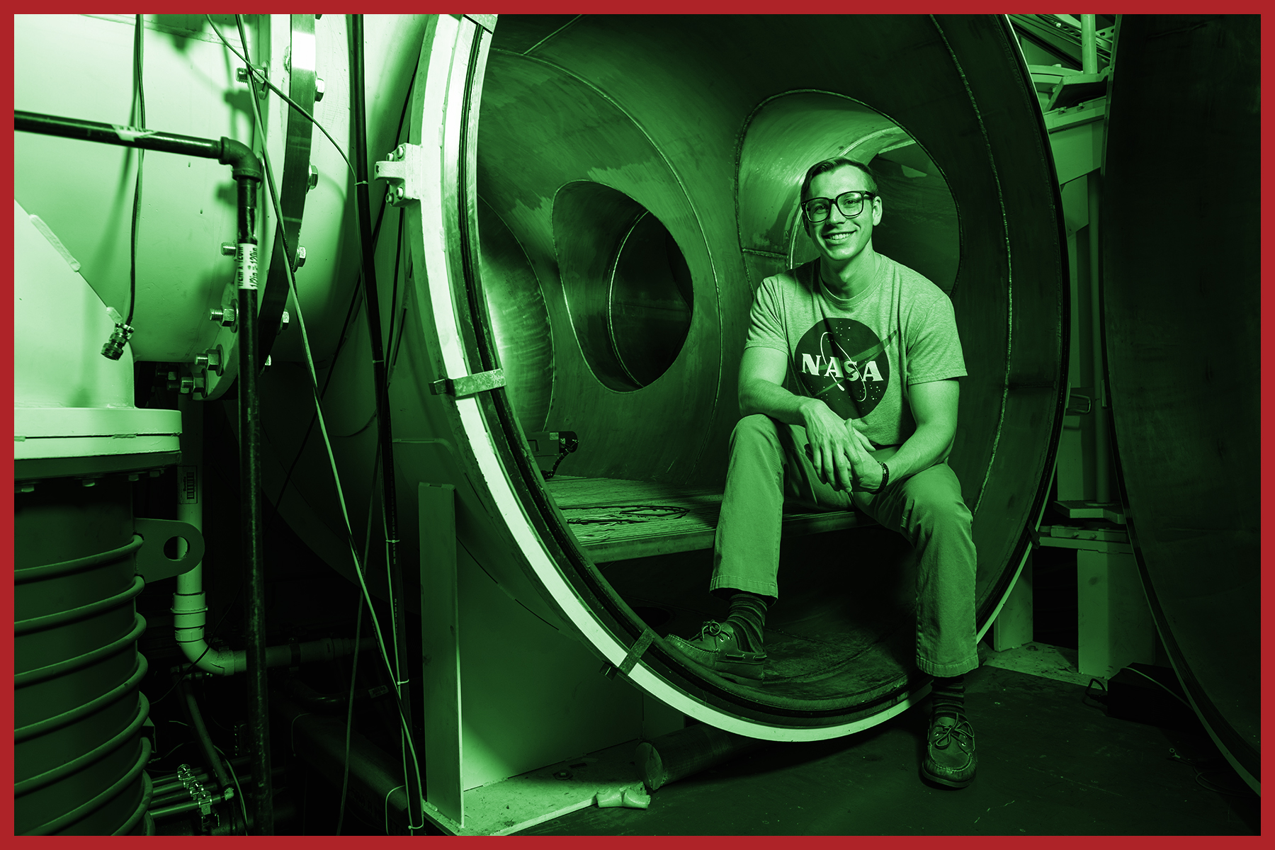Odd duotone image of student sitting on edge of vacuum chamber