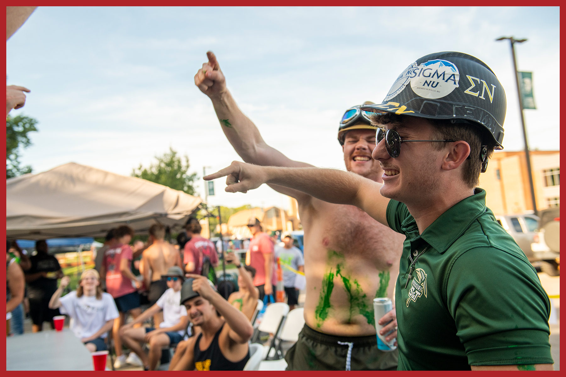 Student drinking without shirt at tailgate before game